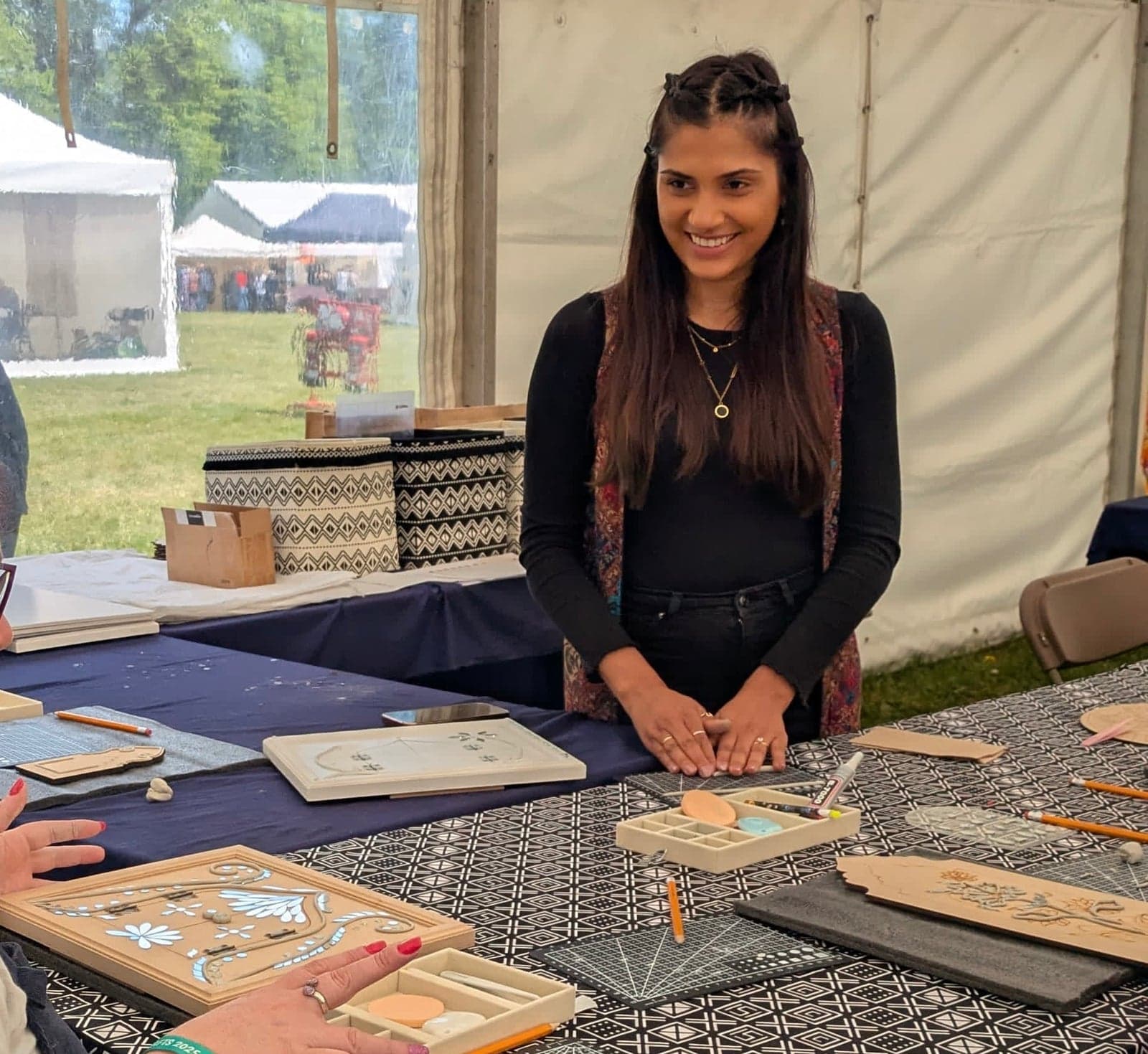 Kalarshi's table of Lippan boards and Jharokha kits inside a craft fair marquee