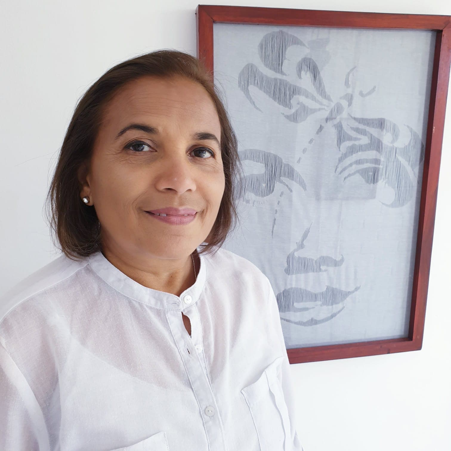 Shraddha Desai smiling beside a framed line drawing